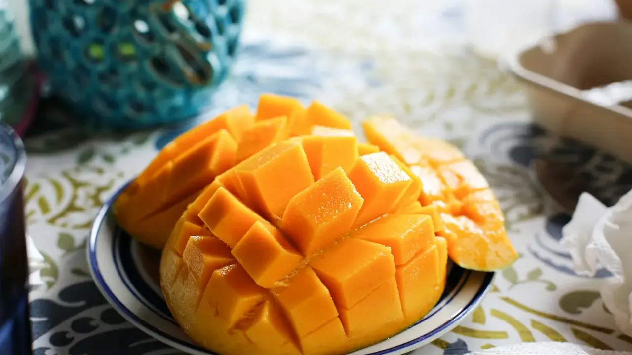 Pokrojone w kostkę mango na talerzyku. Czy pies może mango? To pytanie nurtuje wielu właścicieli czworonogów, ale to owoc dla ludzi.