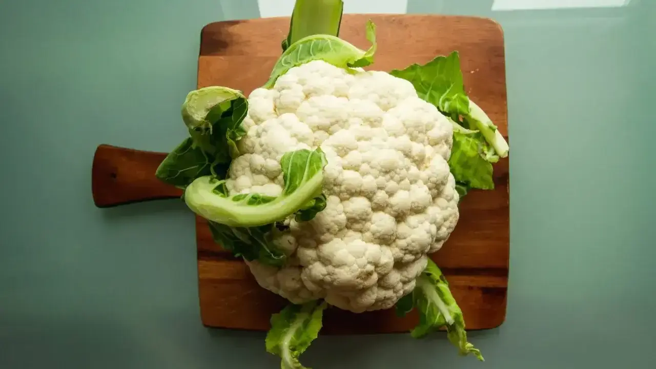 Świeży kalafior na desce. Czy pies może jeść kalafior? Tak, w umiarkowanych ilościach, jako zdrowy dodatek do diety.