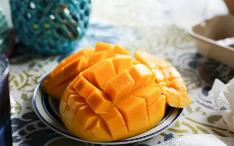 Pokrojone w kostkę mango na talerzyku. Czy pies może mango? To pytanie nurtuje wielu właścicieli czworonogów, ale to owoc dla ludzi.