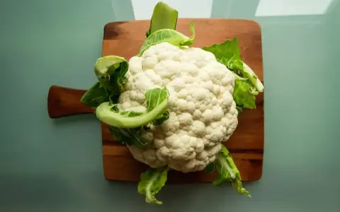 Świeży kalafior na desce. Czy pies może jeść kalafior? Tak, w umiarkowanych ilościach, jako zdrowy dodatek do diety.