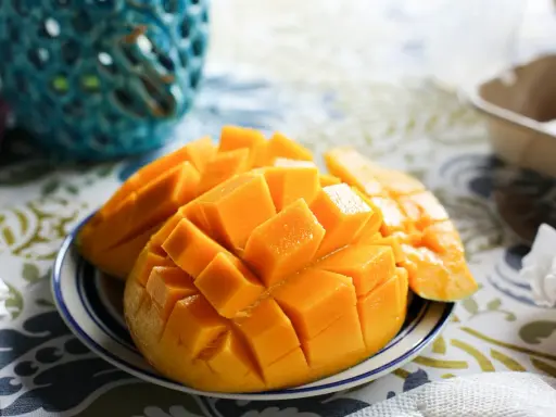 Pokrojone w kostkę mango na talerzyku. Czy pies może mango? To pytanie nurtuje wielu właścicieli czworonogów, ale to owoc dla ludzi.
